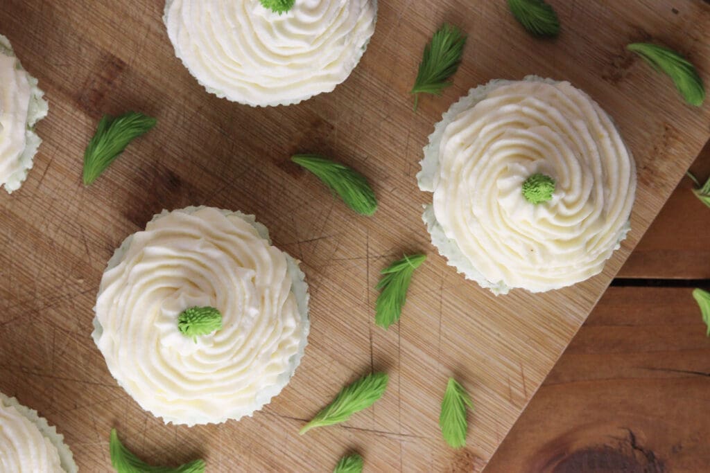 Image of how to decorate spruce tip cakes with lemon curd cream and a spruce tip on top.